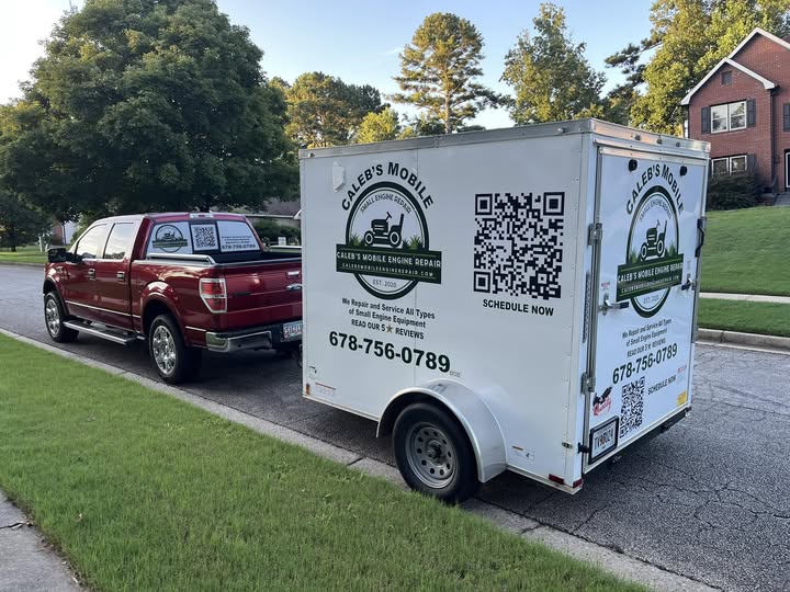 Maroon pickup truck towing a branded white utility trailer for Caleb’s Mobile Small Engine Repair